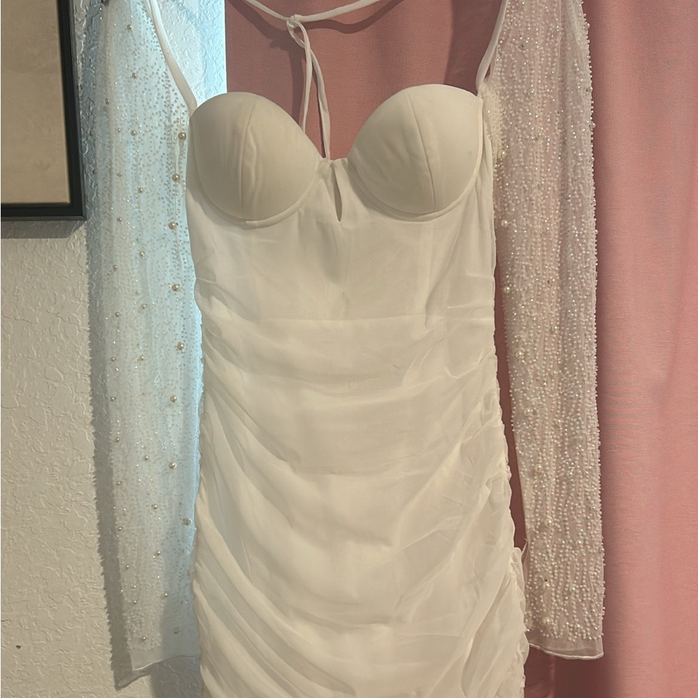 White mini dress with back out and pearl detailing.